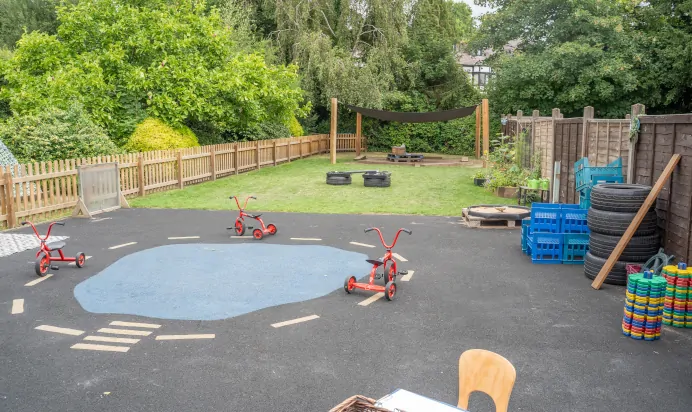 Outdoor play area with tricycles at The Daydream Nursery Preschool Woking