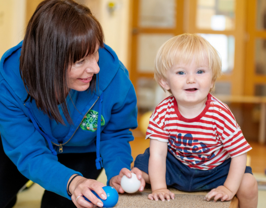 Child and nursery staff playing in the nursery