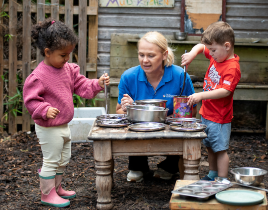 Two children outside playing in the nursery garden