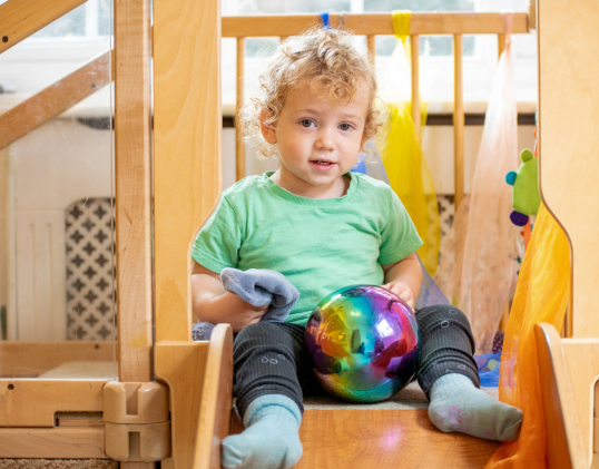 Toddler at nursery playing on a slide