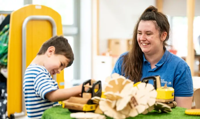 Child laughing and smiling with key worker at Kiddi Caru Day Nursery Preschool Soundwell Bristol