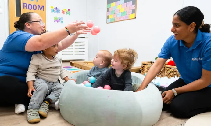 Children playing in ball pit with key workers at Kiddi Caru Day Nursery Preschool Brislington Bristol