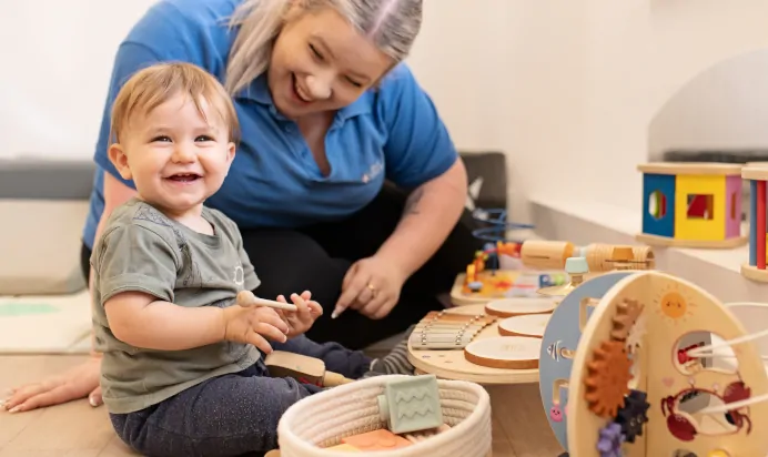 Child smiling with key worker at The Elan Day Nursery Haywards Heath