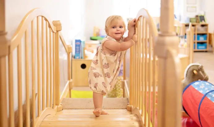 Child walking over wooden bridge at The Elan Day Nursery Haywards Heath