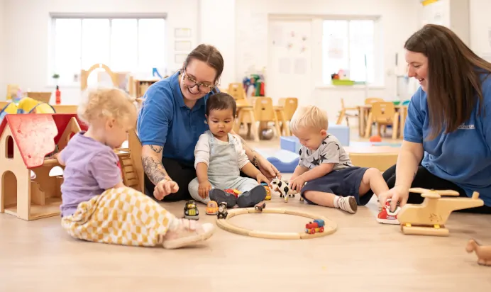 Childing and key workers playing with wooden toys at The Elan Day Nursery Haywards Heath