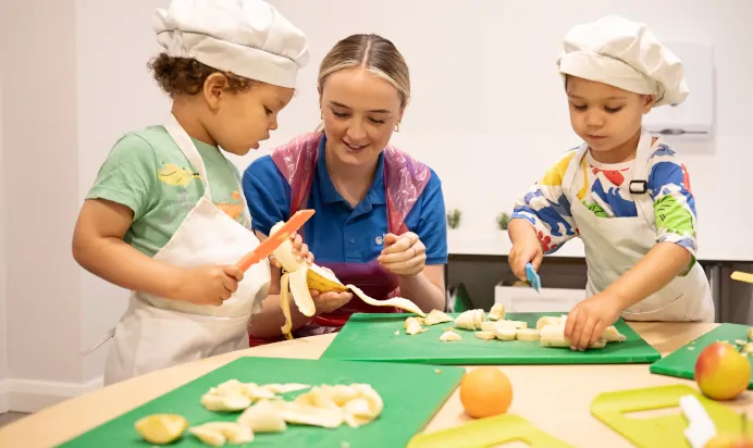 Children preparing food with key worker at The Elan Day Nursery Haywards Heath
