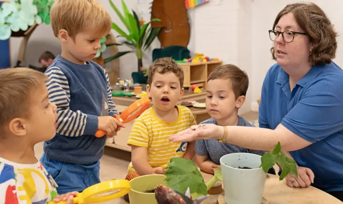 Children using magnifying glass at The Elan Day Nursery Haywards Heath