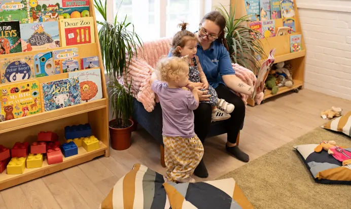 Key worker and children sitting indoors at The Elan Day Nursery Haywards Heath