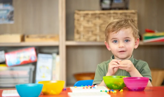 Child playing with plastic screw toy at Lake House Day Nursery Preschool Westbury On Trym Bristol