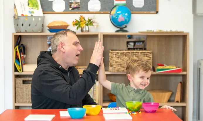 Key worker high fives child at Lake House Day Nursery Preschool Westbury On Trym Bristol