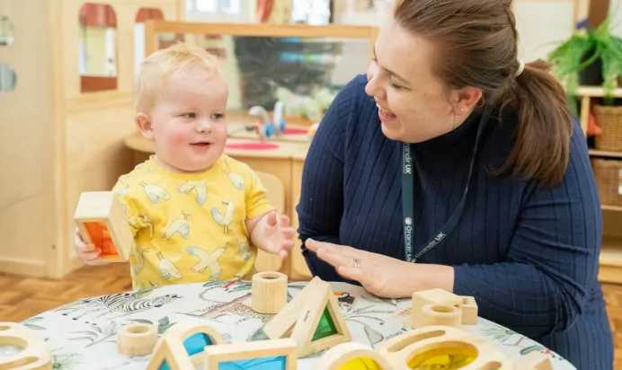 Child laughing with key worker at The Puddleduck Day Nursery St Martins Church Ascot