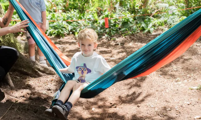 Child smiling from hammock at The Puddleduck Preschool Priory Road Ascot