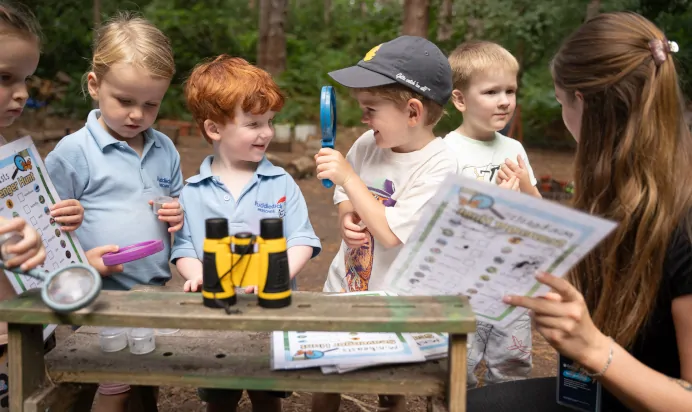 Children in woods learning with key worker at The Puddleduck Preschool Priory Road Ascot