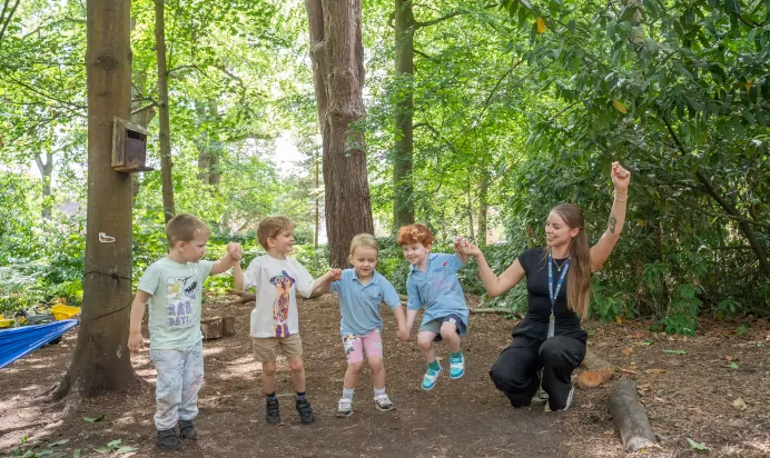 Children jumping together with key worker at The Puddleduck Preschool Priory Road Ascot