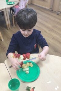 Kiddi Caru children cooking with fruit grown in their nursery vegetable garden as apart of their Eco-Schools activity. 