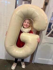 Child at the Chiswick House Day Nursery & Preschool celebrating the nursery's 'Good' Ofsted rating.